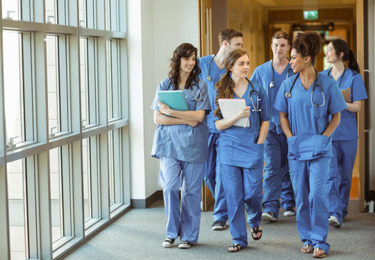 Young Doctors Walking Through Corridor