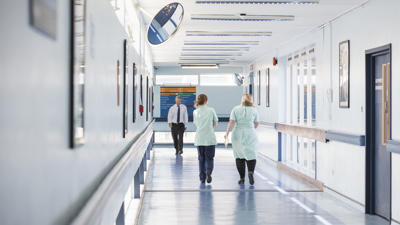 Staff walking down hospital corridor